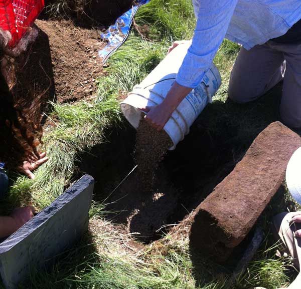 Martha fills the hole with gravel