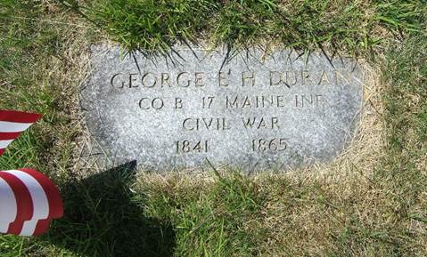 flat granite rectangular gravestone for George Duran set among encroaching sod and a small US flag shadows it