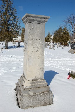 old marble monument in a snow-covered cemetery