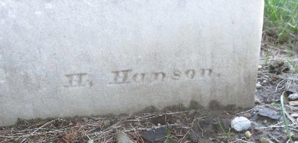 detail from old marble grave marker with carving that says H. Hanson