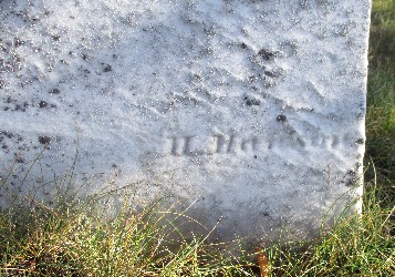 detail of old marble grave marker with carving of H Hanson