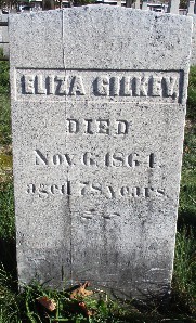 old marble grave marker, a rectangle with a pointed top, carved for Eliza Gilkey whose name in in relief inside of a rectangle