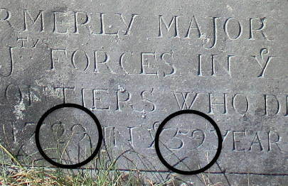 old slate gravestone detail. 2 circles around the 29 and the 59 in the lowest carved line