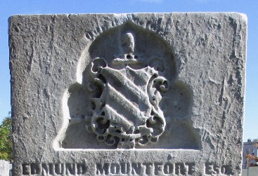 old marble gravestone with a family crest and carved inscription