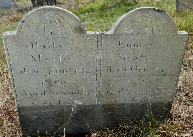 detail of an old slate gravestone carved with umbrella shapes and Polly and Eunice Moody inscriptions