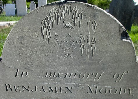 detail of an old slate gravestone carved with a weeping willow over an urn and In memory of Benjamin Moody