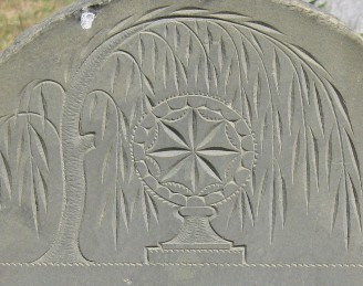 Detail of a slate grave stone with a carving of a monstrance under a weeping willow