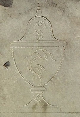 detail of an urn in a slate grave stone carving